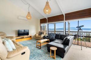 a living room with a couch and a television at South Arm Beach House in South Arm