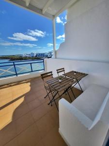 een balkon met een tafel en stoelen en uitzicht op de oceaan bij Mar Bonanza in Orzola