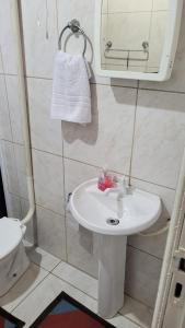 ein Badezimmer mit einem Waschbecken, einem Spiegel und einem WC in der Unterkunft Pousada 4 Estações in Lauro Müller