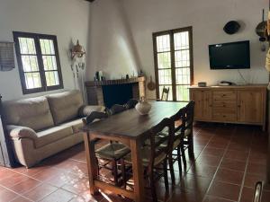 sala de estar con mesa y sofá en Casa de campo Fuencaliente, entorno natural, chimenea, piscina, en Cañete la Real