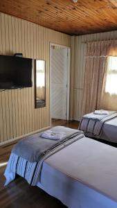 1 Schlafzimmer mit 2 Betten und einem Flachbild-TV in der Unterkunft Pousada 4 Estações in Lauro Müller
