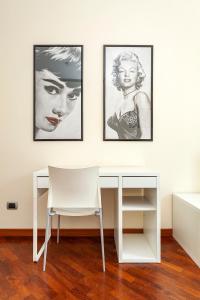 a white desk and a chair in a room with three pictures at Bellezza14 - Appartamento Porta Romana / Bocconi in Milan