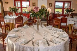 un comedor con una mesa con platos y jarrones de flores en Motelis SMAKŲ SMAKAS en Šiauliai