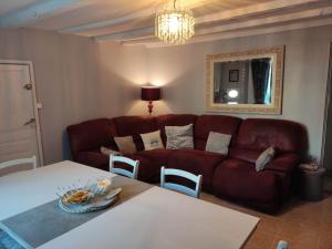 un soggiorno con divano rosso e tavolo di 16 Bel Air a Saint-Bonnet-de-Bellac