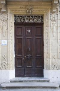 une grande porte en bois sur un bâtiment avec des marches. dans l'établissement Le Jules Appart'Hotel, à Romans-sur-Isère