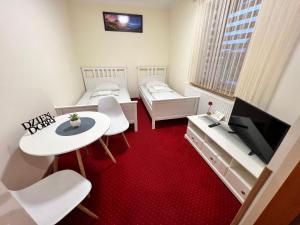 a small room with two beds and a tv at Noclegi AirportPark in Pyrzowice