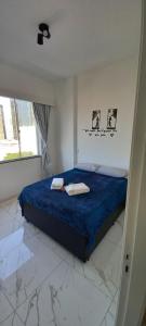 a bedroom with a bed with blue sheets and a window at Lindo apartamento na Lapa in Rio de Janeiro