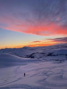 a person skiing down a snow covered slope at sunset at Modern apartment nearby city centrum in Tromsø