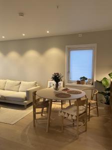 uma sala de estar com uma mesa e um sofá em Modern apartment nearby city centrum em Tromsø