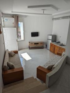 ein Wohnzimmer mit einem Sofa und einem TV in der Unterkunft NN Residence Tabarka in Tabarca