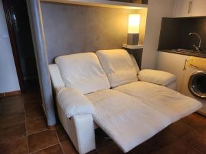 El Apartamento في Ateca: أريكة بيضاء مع وسائد بيضاء جالسة في غرفة