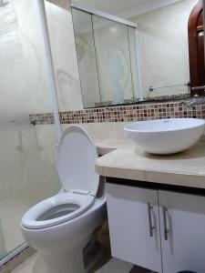 uma casa de banho com um WC branco e um lavatório. em hermoso apartamento la estrella em La Estrella