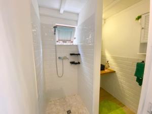 La salle de bains est pourvue d'une douche avec un miroir et un lavabo. dans l'établissement Lodge traditionnel et sa piscine vue mer, à Gallochat