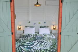 - une chambre avec un lit à motifs tropicaux dans l'établissement Lodge traditionnel et sa piscine vue mer, à Gallochat 22 autres photos