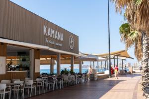 een restaurant op het strand met tafels en stoelen bij Gran terraza, al lado del mar. in Fuengirola