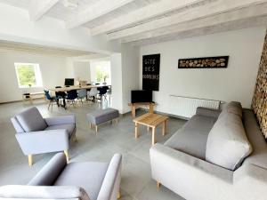 ein Wohnzimmer mit Sofas und ein Esszimmer mit einem Tisch in der Unterkunft Gîte des Rondins in Aumontzey