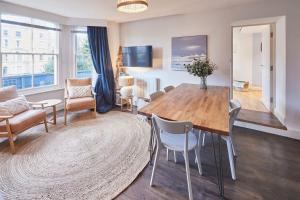 a living room with a wooden table and chairs at South Bay Garden Apartment in Scarborough