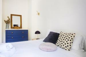 a bedroom with a white bed with a blue dresser and a mirror at Le Jules Appart'Hotel in Romans-sur-Isère