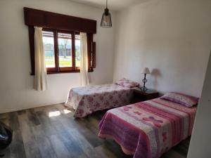 1 dormitorio con 2 camas y ventana en Hermosa vista, en Colonia del Sacramento