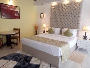 1 dormitorio con 1 cama grande, mesa y mesa en The Grand Leisure, en Iluppankadawala
