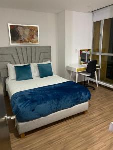 a bedroom with a bed with blue sheets and a desk at Luxury apartment in Armenia
