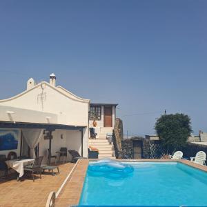 a swimming pool in front of a house at Islabella Lanzarote habitaciones en Villa con entrada particular in Tías