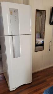 un frigorifero bianco in una camera da letto di 4Estações a Lauro Müller