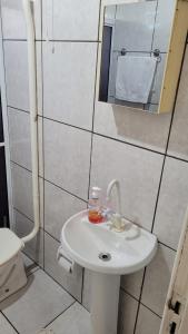 y baño con lavabo blanco y espejo. en 4Estações, en Lauro Müller