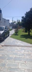 un'auto parcheggiata accanto a un vialetto di pietra di Casa Olivia- Alojamiento con piscina - Aeropuerto Ezeiza a Ezeiza