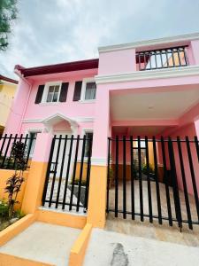 una casa rosa con una valla negra en Cara Transient house, en San Pablo