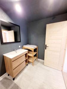 ein Bad mit einem Waschbecken und einem Spiegel in der Unterkunft Gîte des Rondins in Aumontzey
