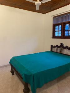 Mal villa في يوناواتونا: غرفة نوم عليها سرير وبطانية زرقاء