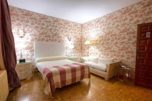 1 dormitorio con 1 cama y 1 sofá en Complejo Rural Victory en Cuenca