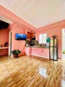 an empty kitchen with pink walls and wooden floors at Cara Transient house in San Pablo