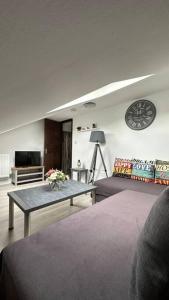 Palaz 8 - One Bedroom Flat في إدمونتون: غرفة معيشة مع طاولة وساعة على الحائط