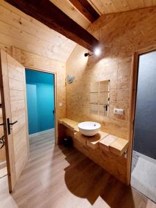 ein Bad mit einem weißen Waschbecken im Zimmer in der Unterkunft Gîte des Rondins in Aumontzey
