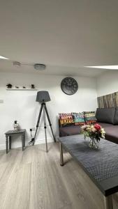a living room with a couch and a clock on the wall at Palaz 8 - One Bedroom Flat in Edmonton