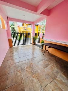 Habitación con paredes rosas y banco en el suelo de baldosa. en Cara Transient house, en San Pablo