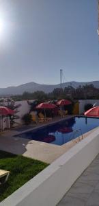 a swimming pool with tables and umbrellas on a building at NN Residence Tabarka in Tabarka