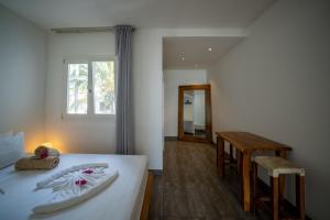 um quarto com uma cama, uma mesa e uma janela em Ocean View Junior Suite Tatu ZanzibarHouses em Kiwengwa