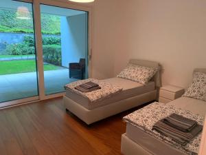 ein Wohnzimmer mit Sofa und Ottomane in der Unterkunft Luxusapartment an Traumlage in Lugano in Paradiso