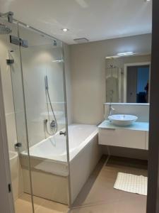 ein Badezimmer mit einer Dusche, einer Badewanne und einem Waschbecken in der Unterkunft Luxusapartment an Traumlage in Lugano in Paradiso