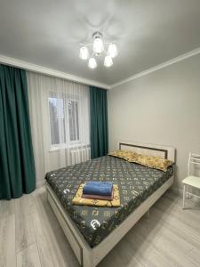 um quarto com uma cama num quarto com cortinas verdes em Apartment in street Toktogula 77 em Bishkek
