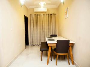 a dining room with a table and black chairs at Duke Diamonds Apartments in Abuja