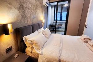 1 dormitorio con 1 cama con sábanas y almohadas blancas en CharmAntique Apartments, en Tirana