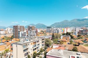 una ciudad con edificios y montañas en el fondo en CharmAntique Apartments, en Tirana