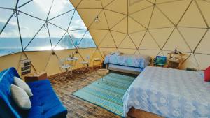 a bedroom with a tent with a bed and a couch at Andes Glamping in Guatavita