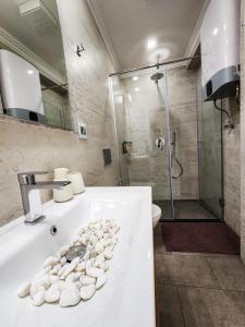uma casa de banho com uma banheira com pedras em CharmAntique Apartments em Tirana