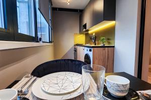 mesa de comedor con silla negra y cocina en CharmAntique Apartments, en Tirana