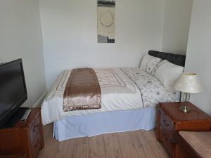a bedroom with a bed and a flat screen tv at Maryann's in Huddersfield